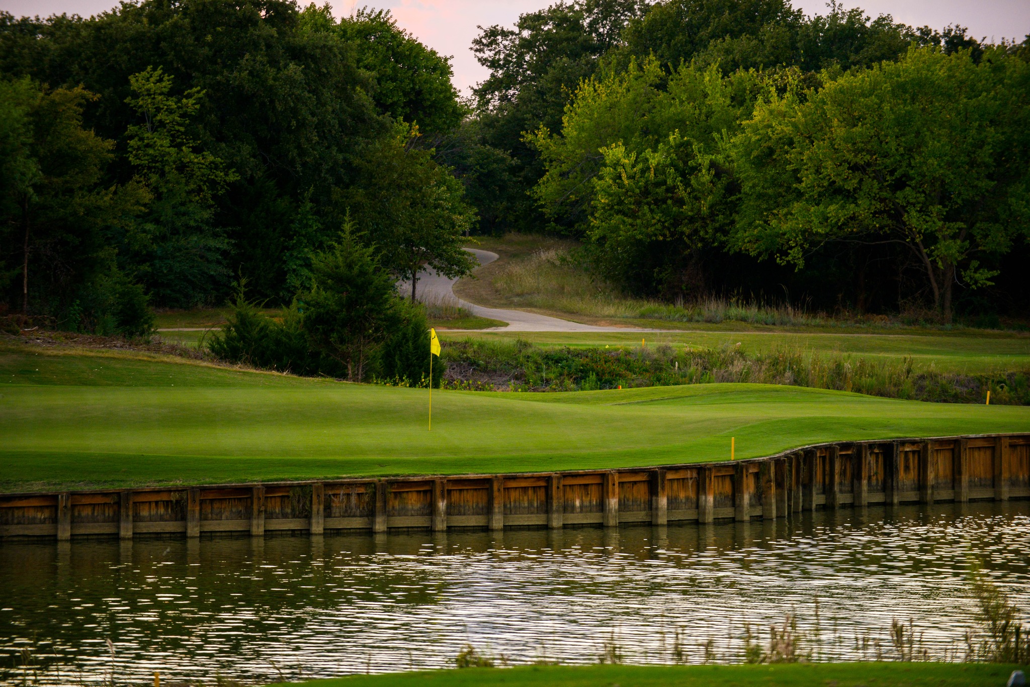 Flag on golf course in front of pond